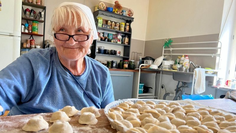 Babička připravuje koláče z kynutého těsta