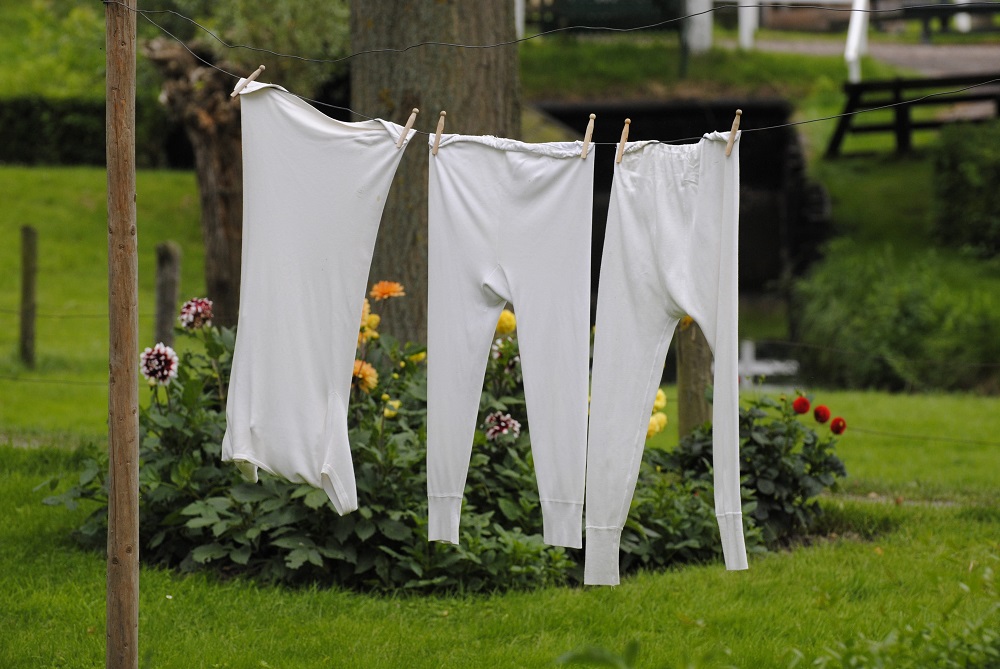 Bílé prádlo pověšené venku na sušáku