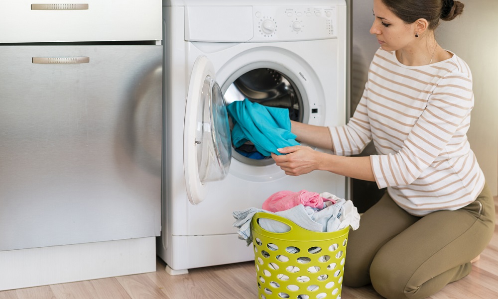 žena vytahuje prádlo z pračky